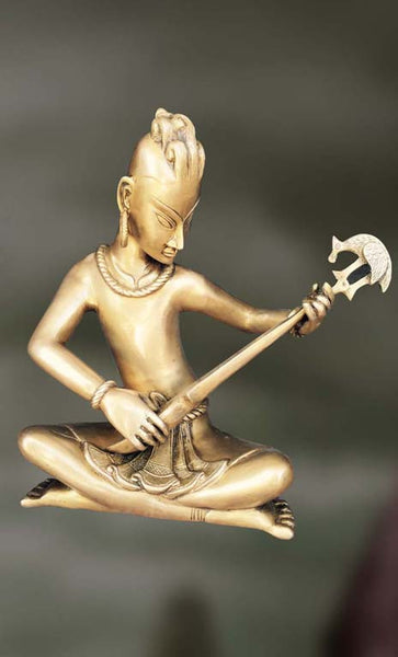 Brass Sculpture of man playing long pipe  